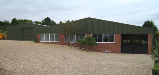 Steel and brick retail unit on a farm with a storage shed in the background